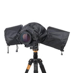 DSLR camera fully enclosed in a black rain cover mounted on a tripod, lens exposed for shooting.