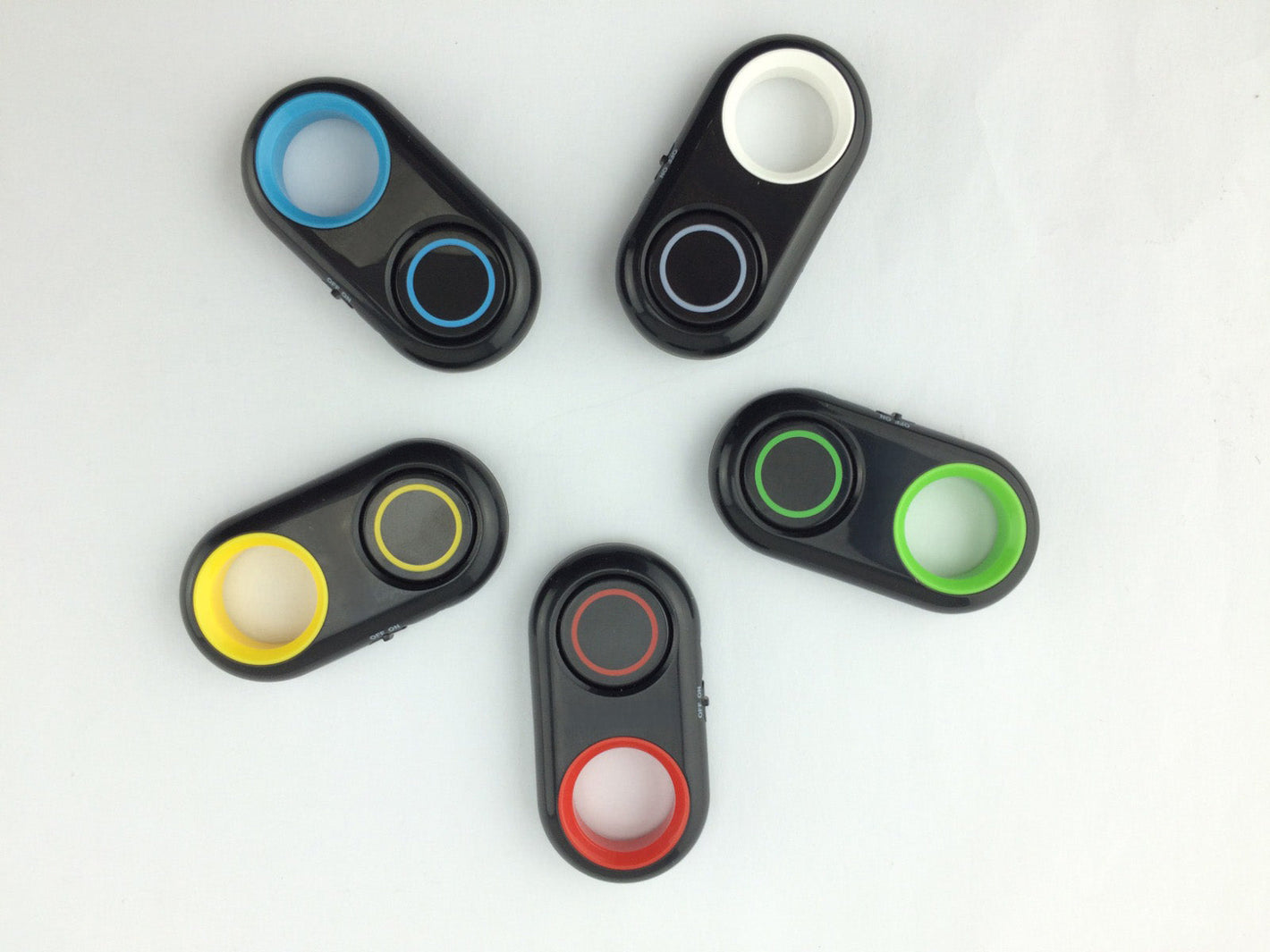 Bluetooth camera remotes in black with red, blue, green, yellow, and white accents arranged in a circular layout