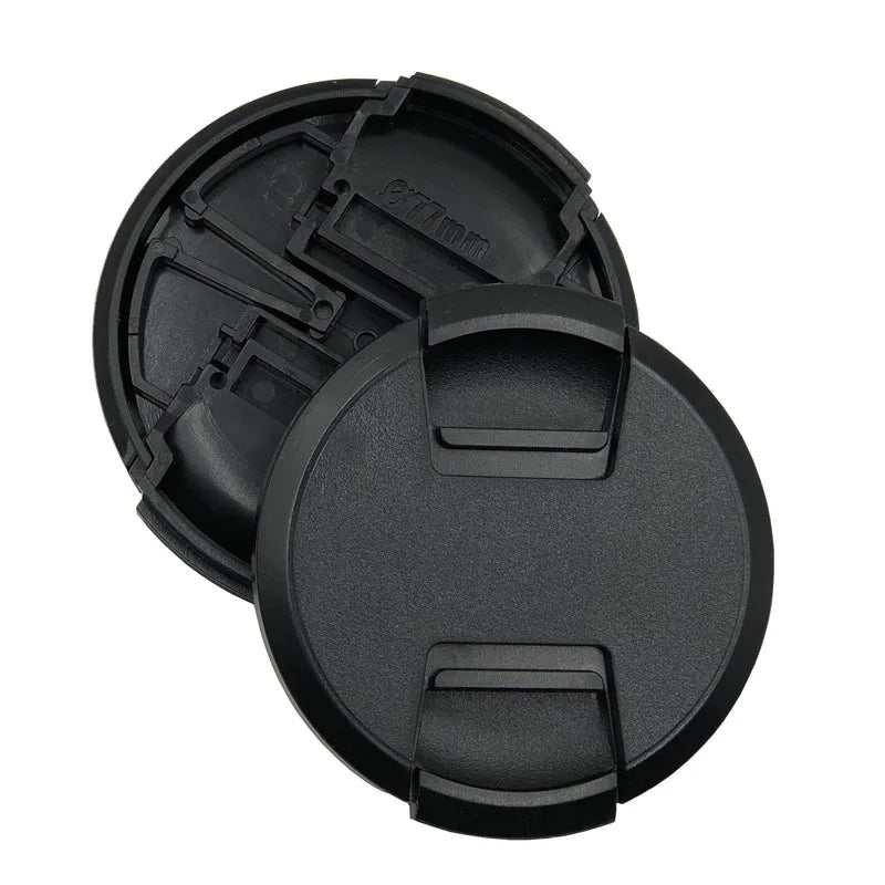 Two black camera lens caps on a white background