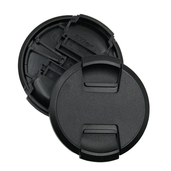 Two black camera lens caps on a white background